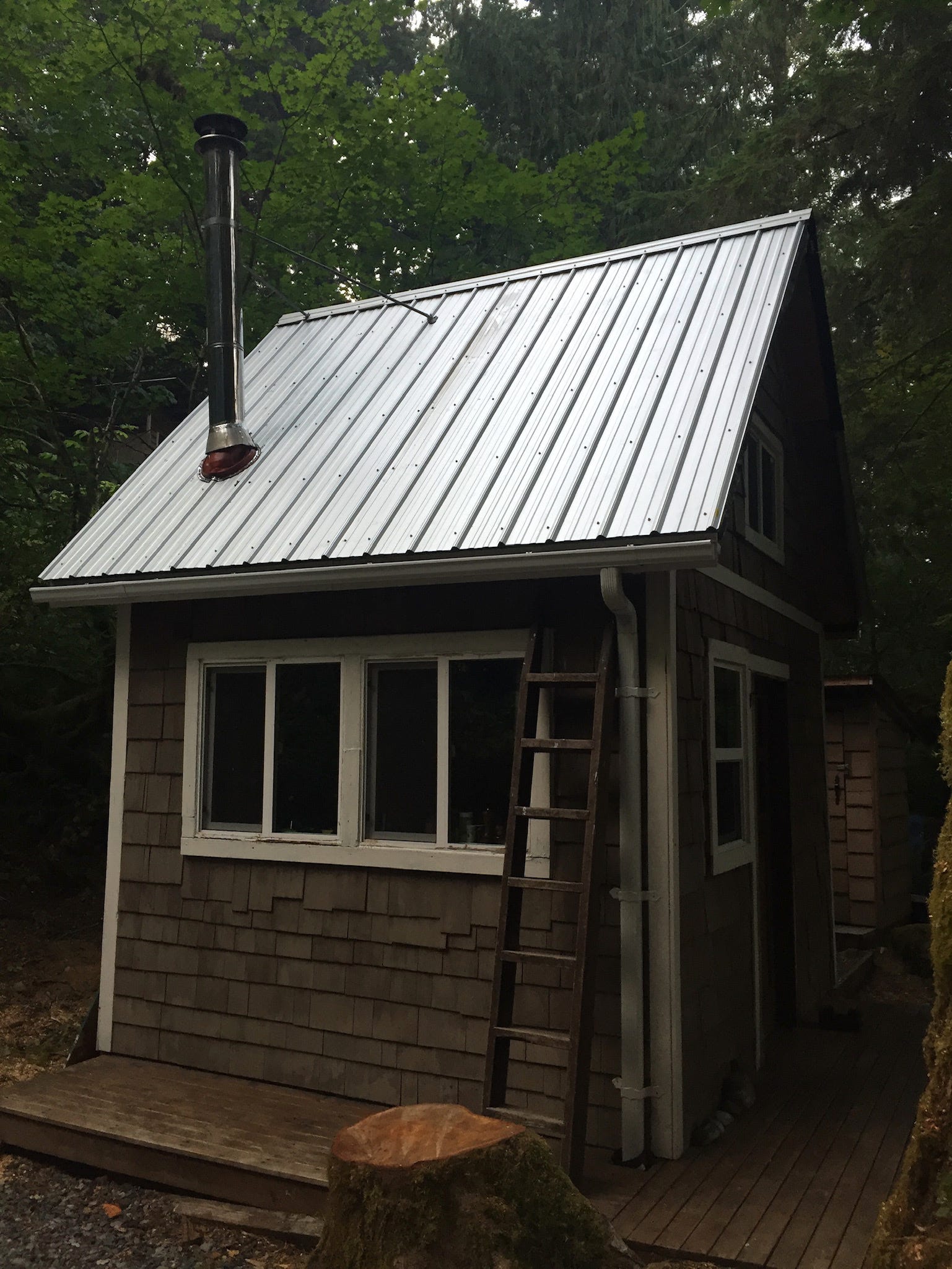Dieses Bild der Hütte wurde aufgenommen, nachdem das Dach aufgesetzt worden war, aber das Plumpsklo ist im Hintergrund zu sehen.